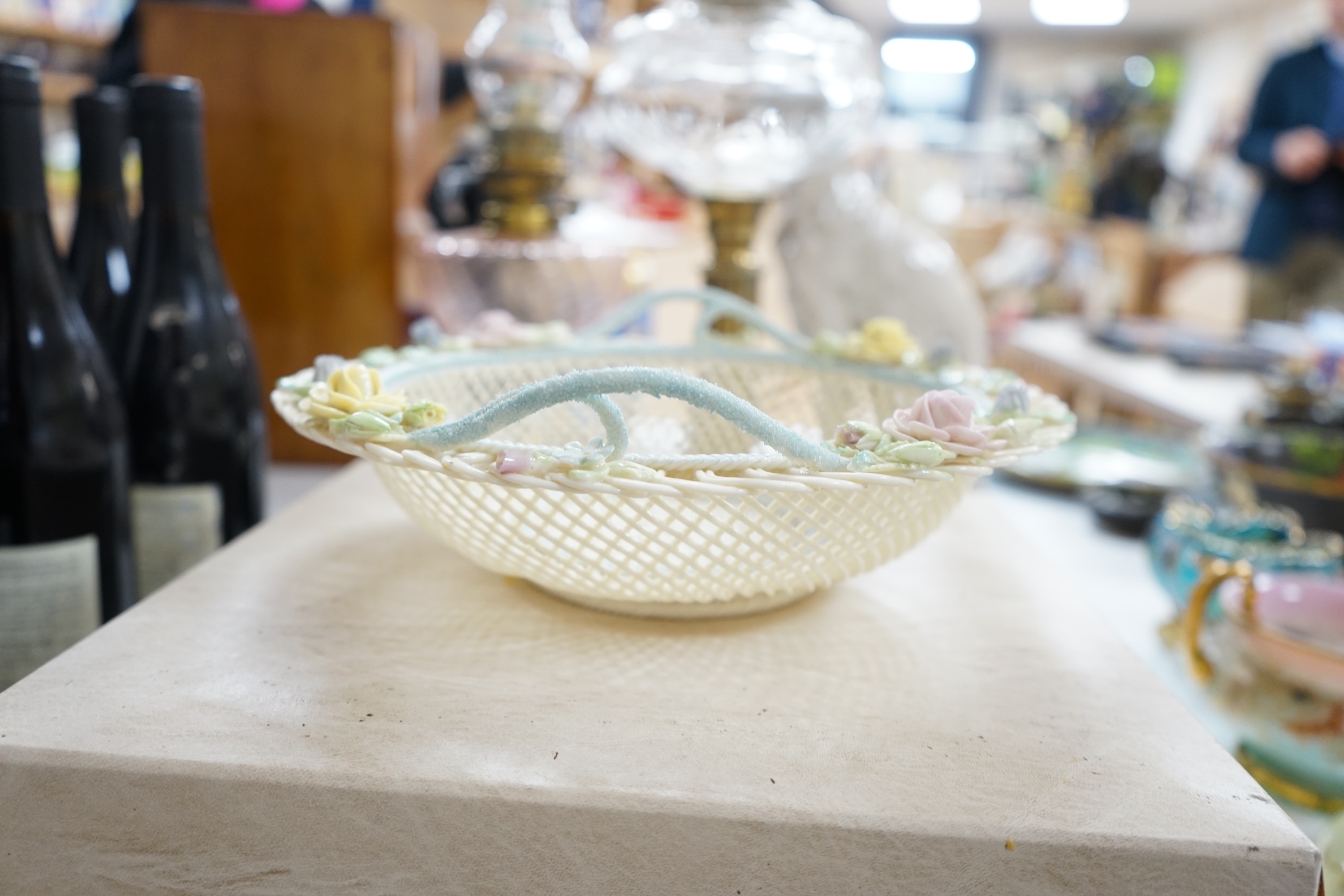 A boxed Belleek coloured basket, 28cm diameter. Condition - fair to good, some damage and wear to the box.